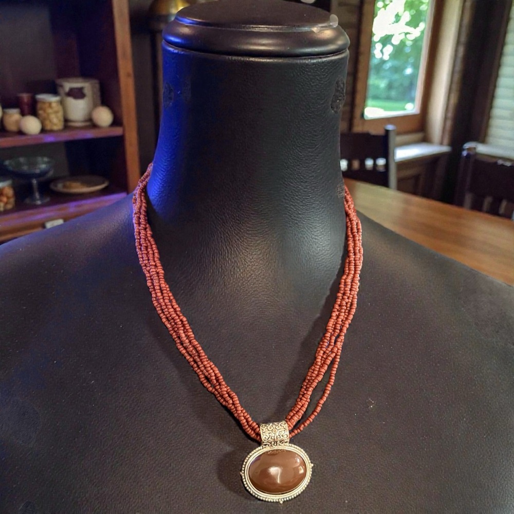 Elegant Beaded Necklace with Silver and Brown Pendant